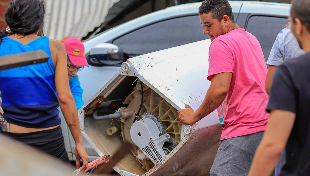 Moradores tentam retirar objetos após enxurrada