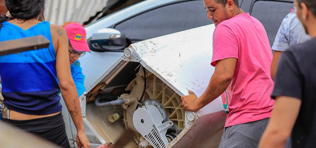 Moradores tentam retirar objetos após enxurrada