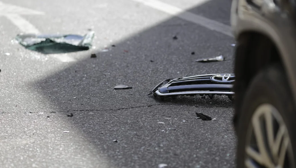 Pedaços do para-choque do carro ficaram no chão