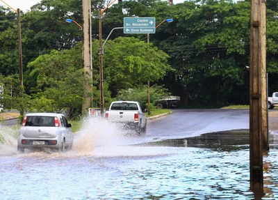 Veículos passam em avenida alagada após chuva em Teresina
