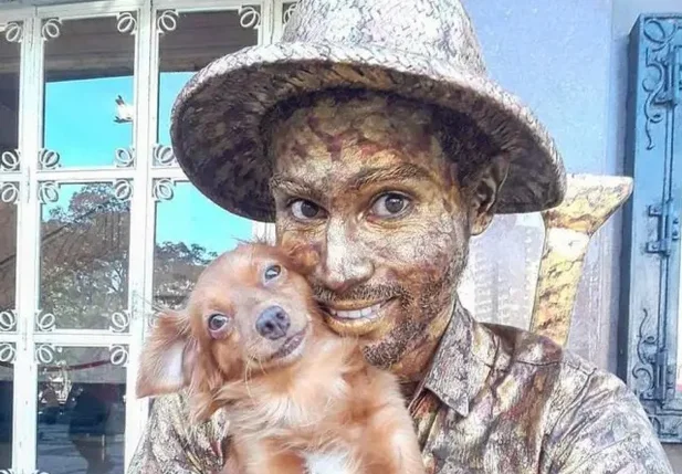 Yorge Luís Ruiz, artista de rua e imigrante venezuelano que trabalha como estátua viva em Fortaleza, Ceará, com sua cachorrinha
