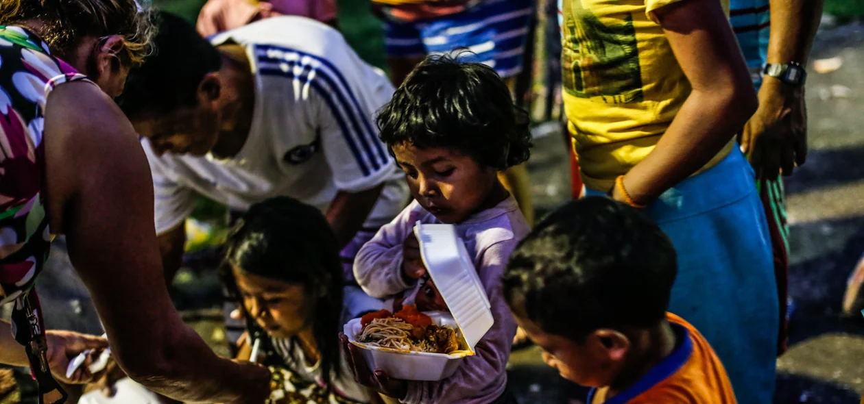 Crianças recebendo comida 