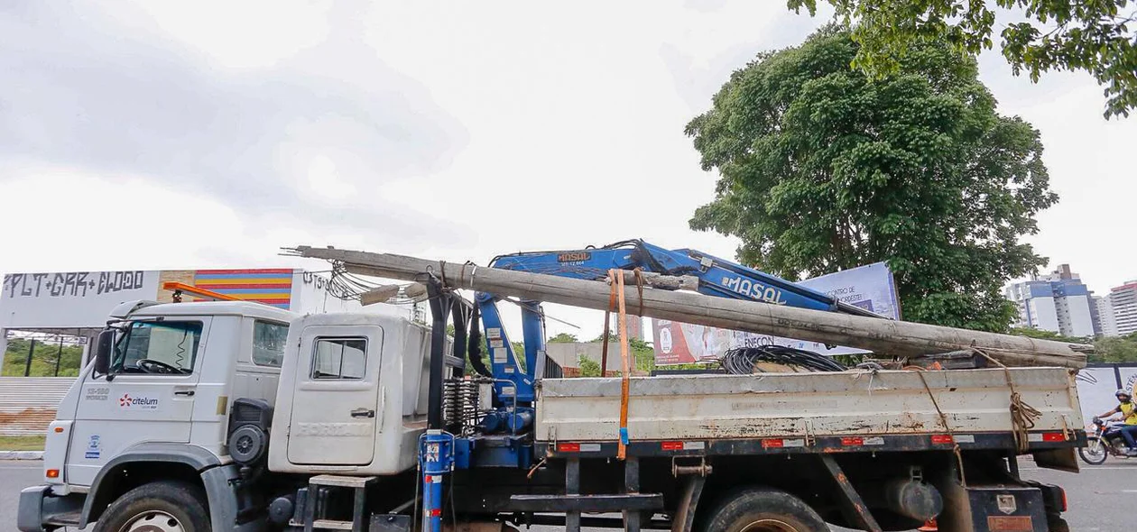 Caminhão recolhendo poste danificado