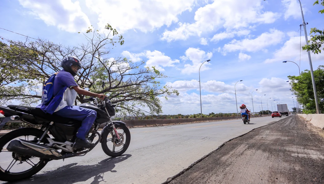 Motoqueiro passando pela ponte