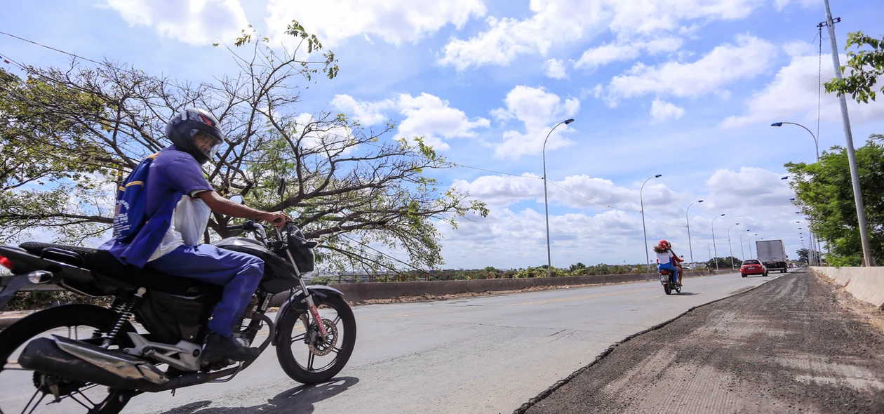 Motoqueiro passando pela ponte