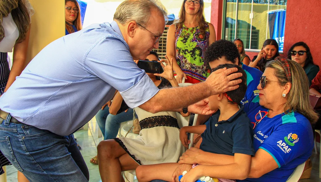 Prefeito Firmino Filho cumprimentando criança 