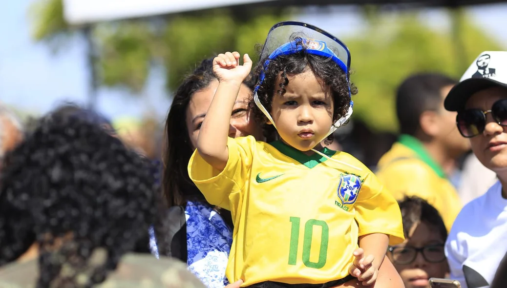 Criança vestida com a camisa do Brasil espera a chegada de Bolsonaro a Parnaíba