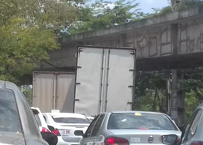 Caminhão fica preso ao tentar passar sob viaduto
