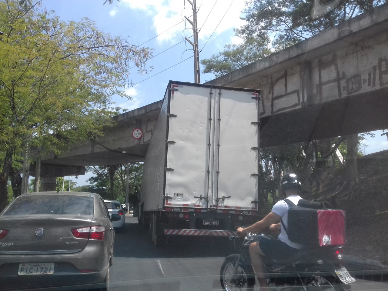Caminhão fica preso ao tentar passar sob viaduto
