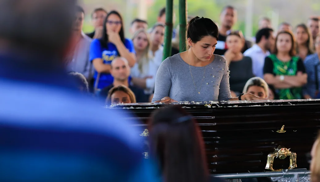 Esposa ao lado do caixão 