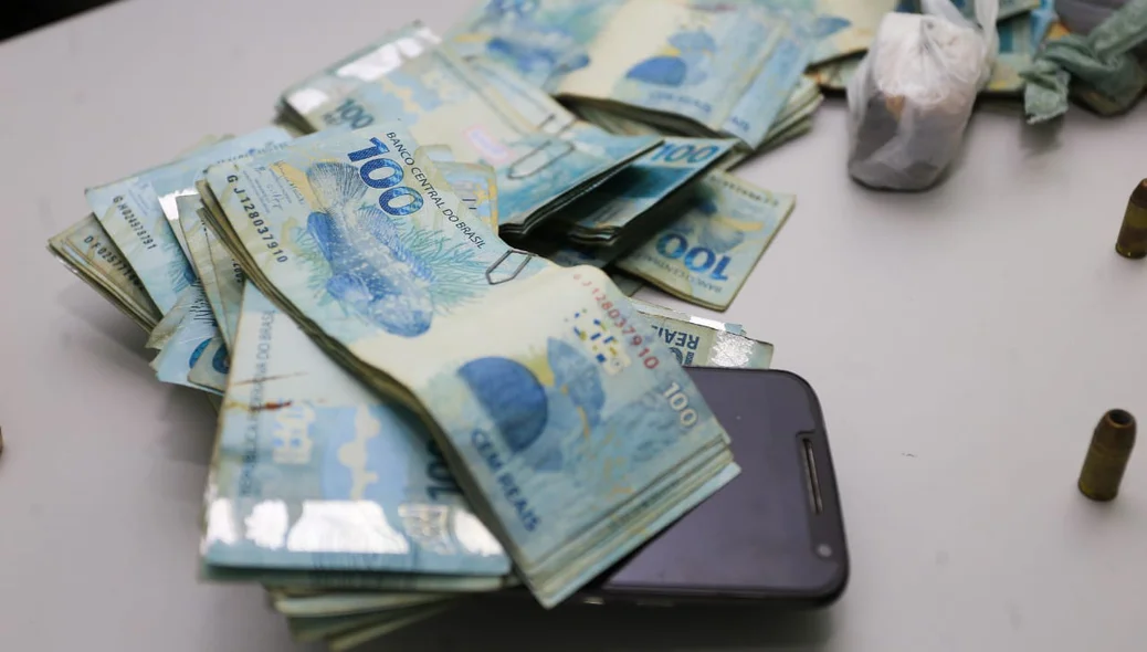 Além do dinheiro, a polícia apreendeu um celular 