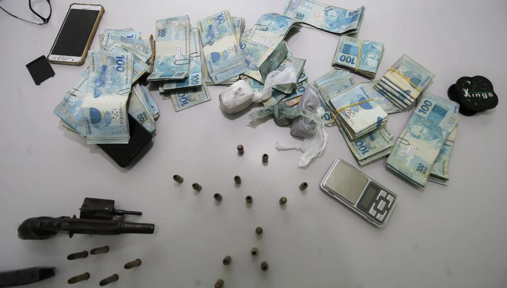 Dinheiro e arma apreendida pela polícia 