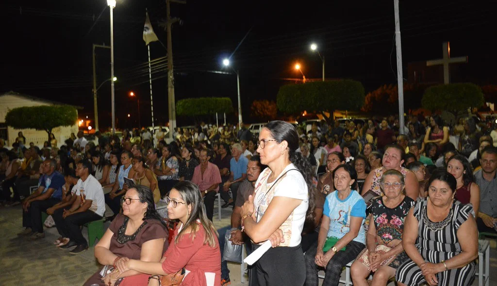 Devido a lotação devotos assistem missa do lado de fora da igreja