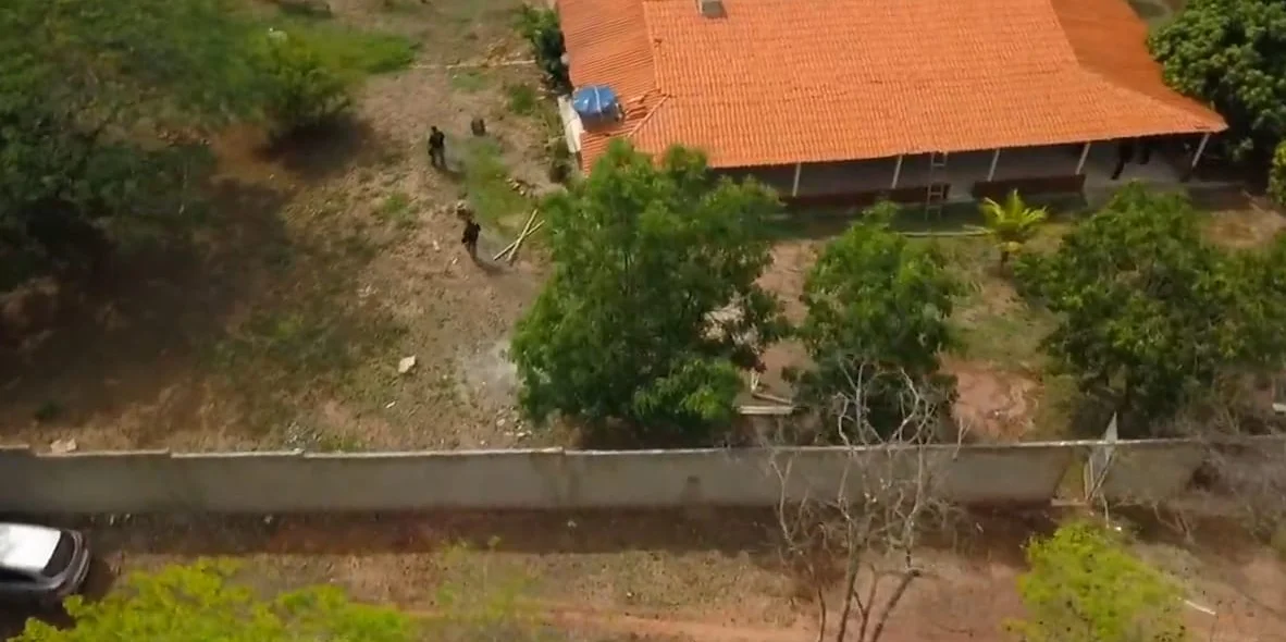 Agentes policias realizando buscas nas proximidades da casa