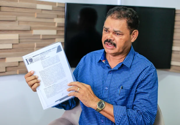 Ex-prefeito Zé Medeiros segurando o documento 