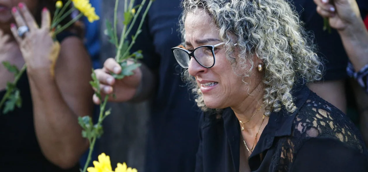 Mulher emocionada no sepultamento de Fernando Monteiro