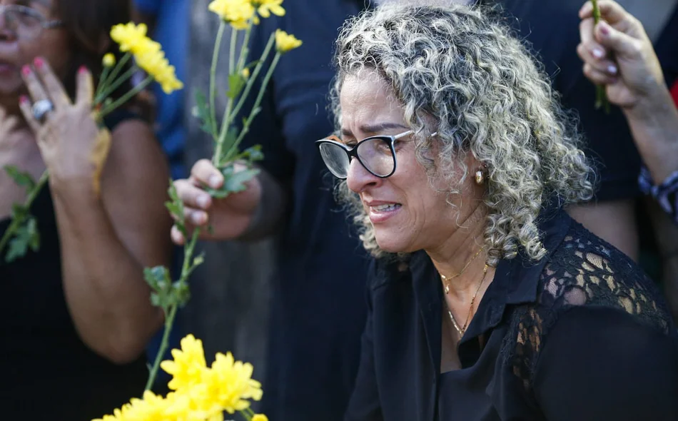 Mulher emocionada no sepultamento de Fernando Monteiro