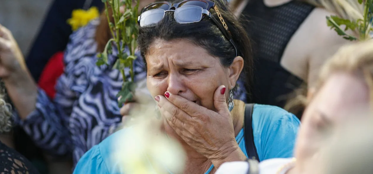 Senhora emocionada no sepultamento de Fernando Monteiro