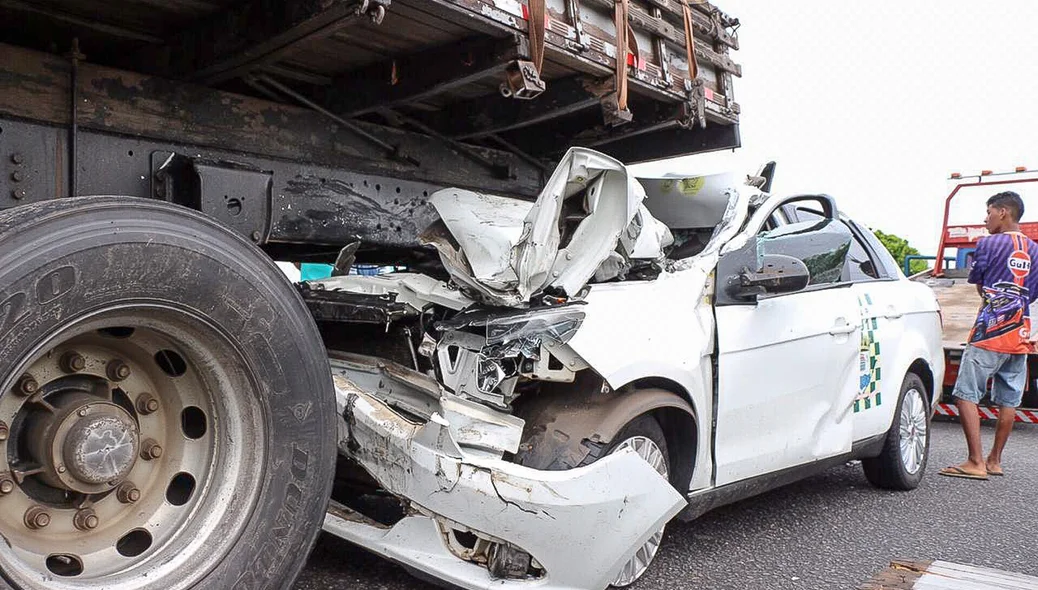 Táxi colide em caminhão e fica totalmente destruído
