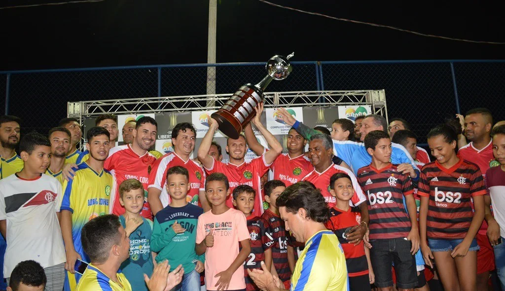 Rodeado de amigos Renê levanta taça