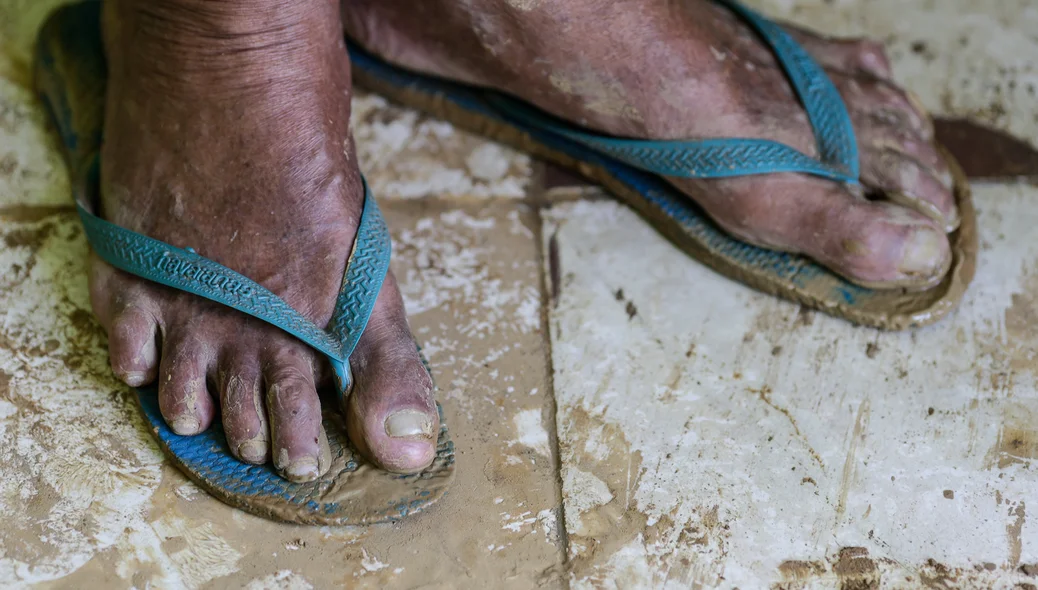 Seu Luís com os pés melados de lama 