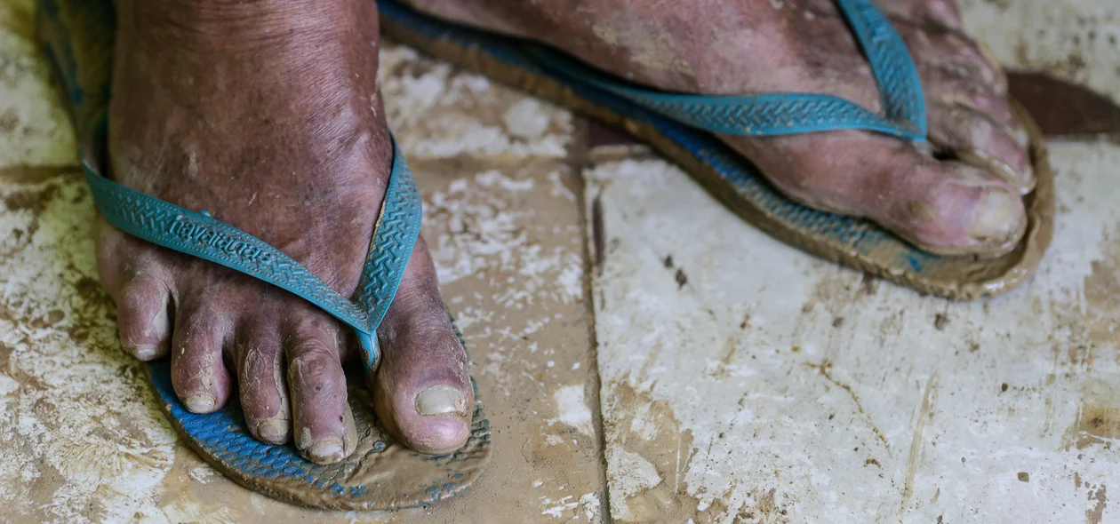 Seu Luís com os pés melados de lama 
