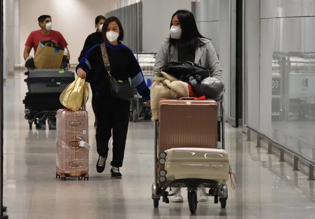 Passageiros desembarcam no Aeroporto de Guarulhos com máscaras devido ao coronavírus