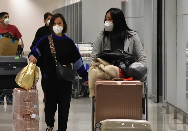Passageiros desembarcam no Aeroporto de Guarulhos com máscaras devido ao coronavírus