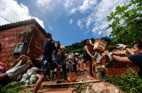Voluntários colaboram com agentes do Corpo de Bombeiros, no Morro do Macaco Molhado, no Guarujá, litoral sul de São Paulo