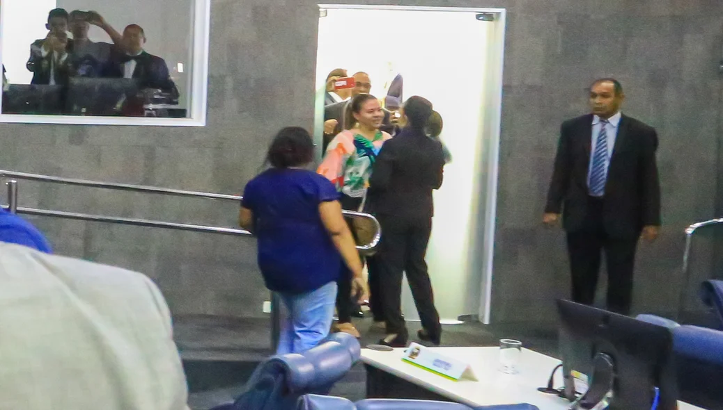 Momento em que Teresinha Medeiros é barrada por manifestante ao tentar sair do plenário 