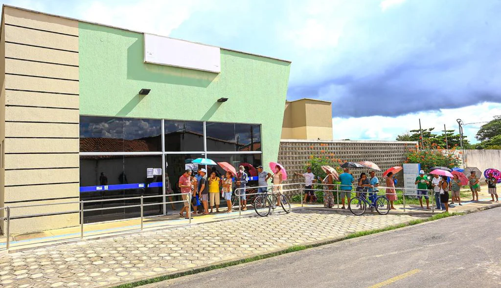 Idosos em fila no sol quente 