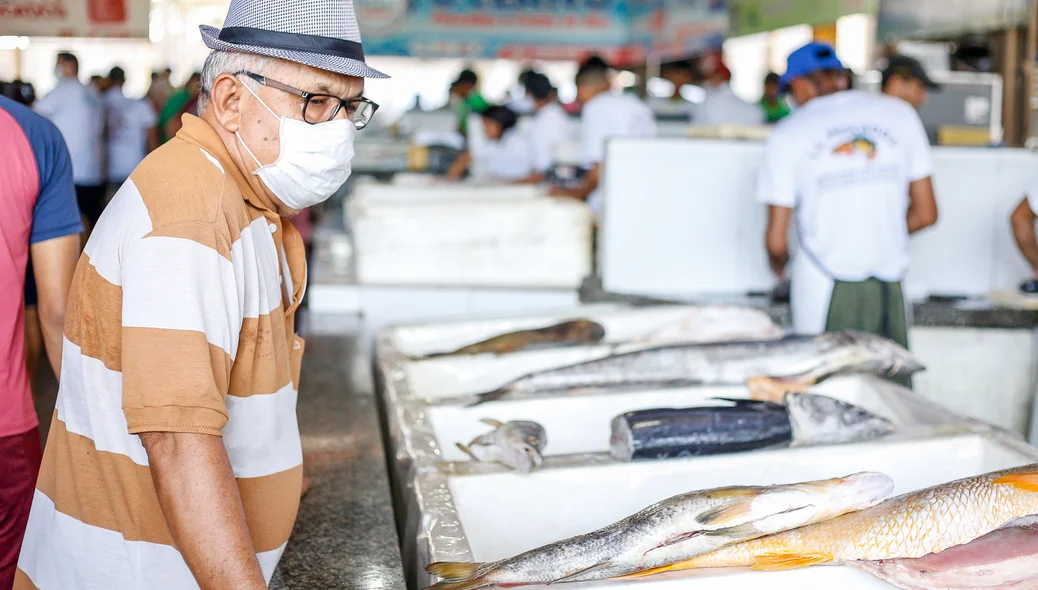 Idoso se prevenindo ao ir comprar peixe