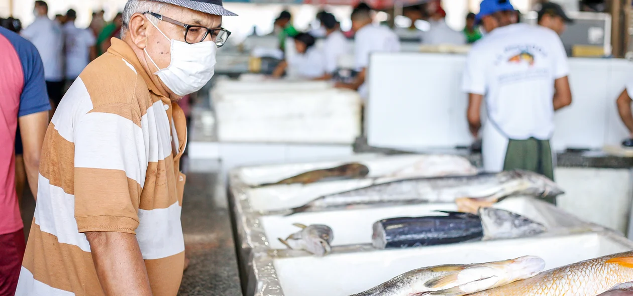 Idoso se prevenindo ao ir comprar peixe