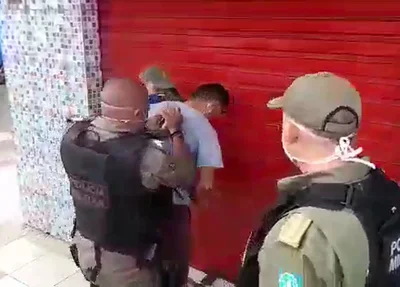 Comerciante sendo algemado pela PM