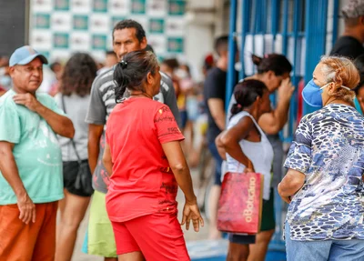 Pessoas com e sem mascaras na fila da loteria do Mocambinho