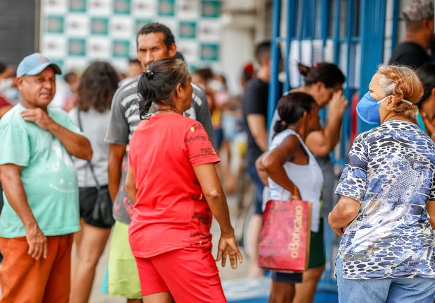Pessoas com e sem mascaras na fila da loteria do Mocambinho
