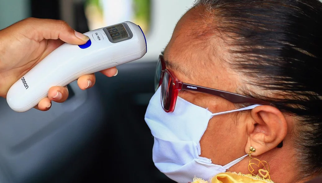 Guarda mede temperatura da senhora durante barreira sanitária