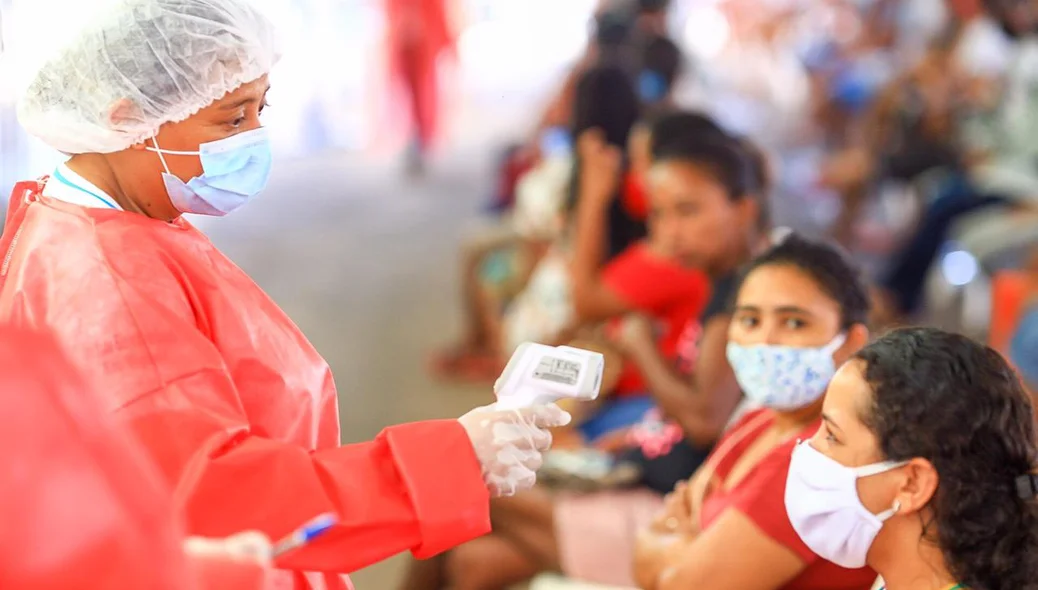 Agente de saúde mede a temperatura da população