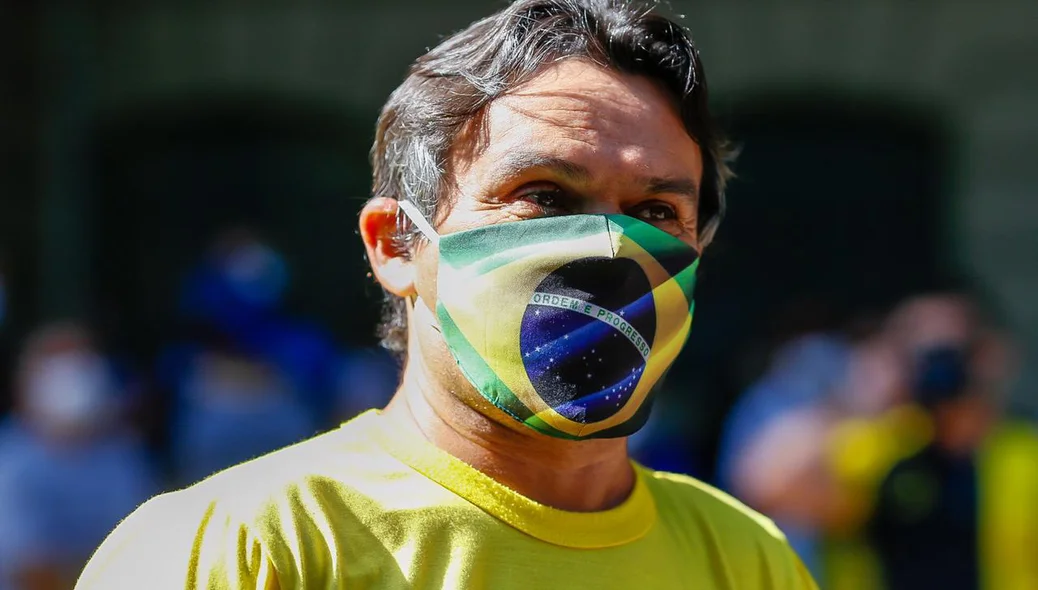 Manifestante com máscara da bandeira do Brasil