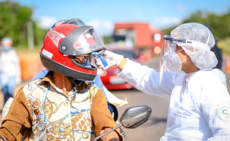 Agente de Saúde medindo a temperatura dos motoqueiros
