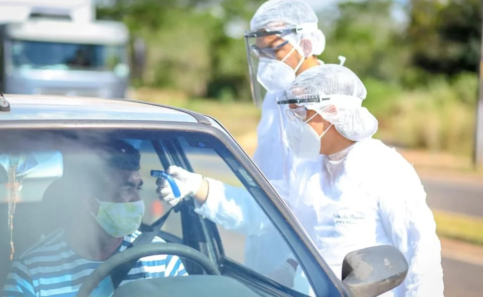 Agentes medindo a temperatura dos motoristas 