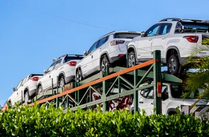Cegonha com carros na concessionária 