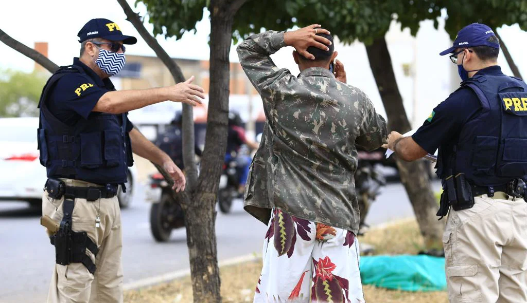 Policiais tranquilizando irmão da vítima 