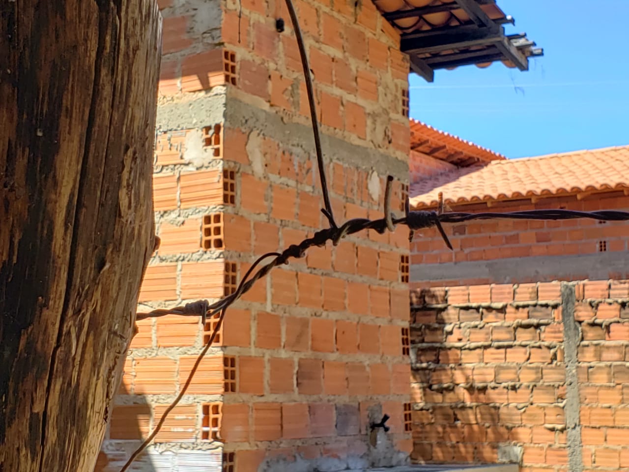 Fio elétrico amarrado à cerca de arame farpado
