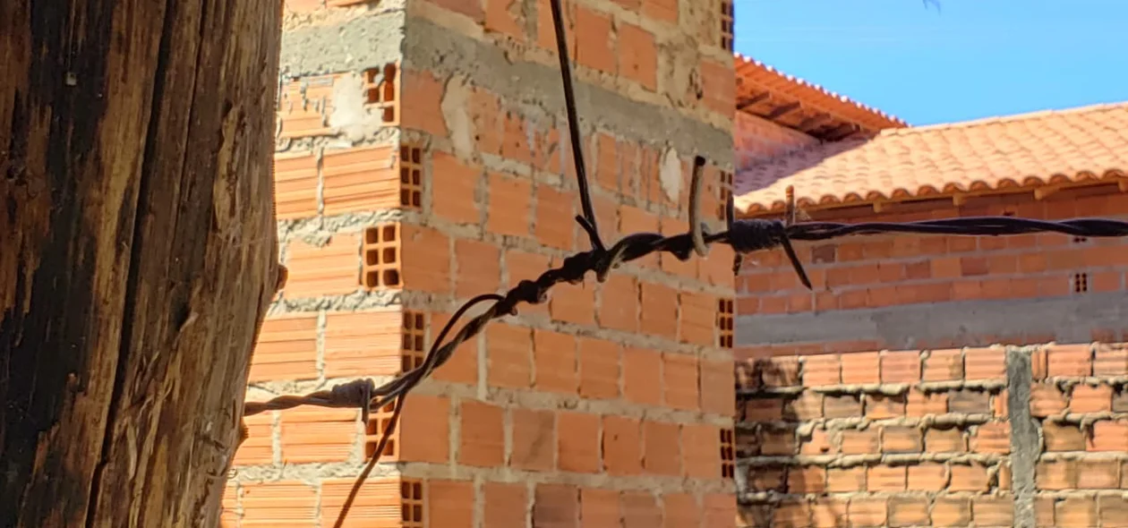 Fio elétrico amarrado à cerca de arame farpado