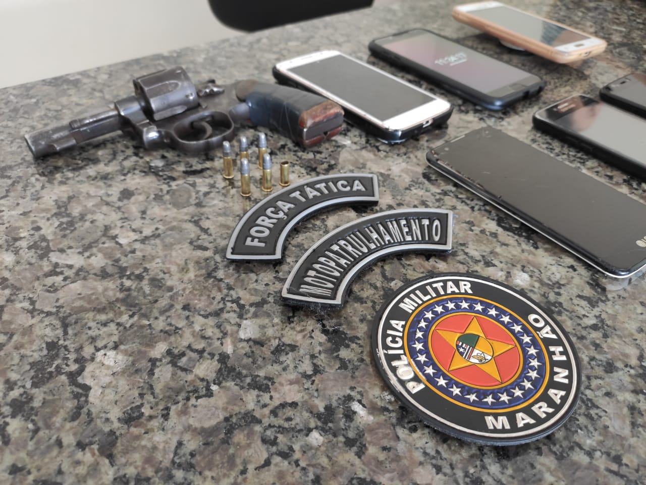 Arma de fogo e celulares apreendidos