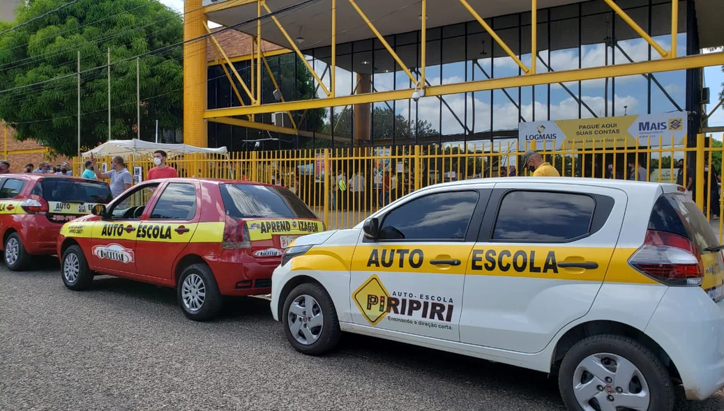 Carros de autoescolas estacionados na frente do Detran