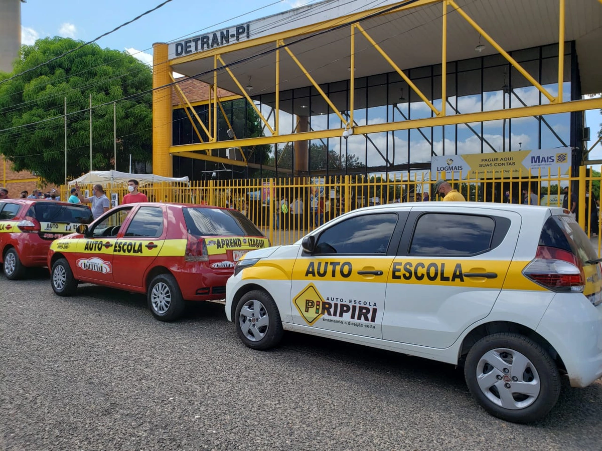 Carros de autoescolas estacionados na frente do Detran