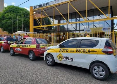 Carros de autoescolas estacionados na frente do Detran