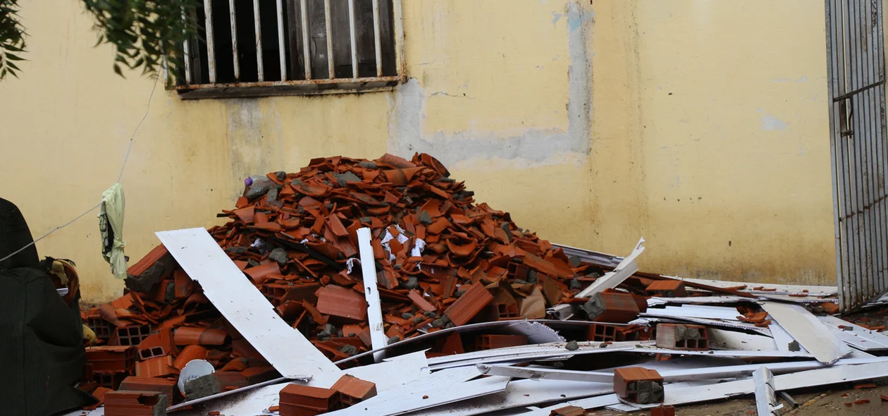Moradores retiram restos do telhado de dentro da casa